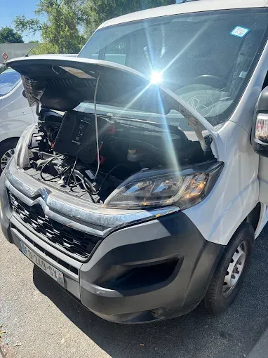 Capot ouvert sur un Citroën Jumper pendant un dépannage batterie avec booster